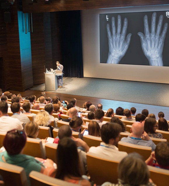 Hington Klarsey: professor teachning to college med students in a large auditorium